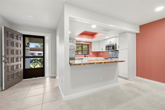 2510 Laurelwood Dr Unit 5B, Clearwater, FL 33763 - kitchen featuring appliances with stainless steel finishes, recessed lighting, white cabinets, baseboards, and a peninsula