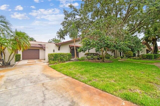 3476 Tarpon Woods Blvd, Palm Harbor, FL 34685 - view of front of house featuring stucco siding, concrete driveway, a garage, a front yard, and a tiled roof