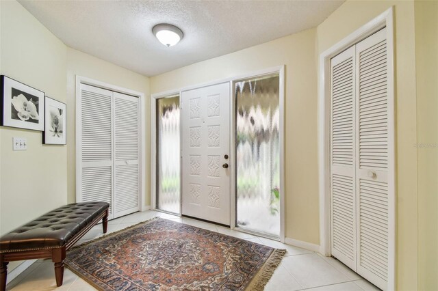 3476 Tarpon Woods Blvd, Palm Harbor, FL 34685 - entrance foyer with light tile patterned floors, a textured ceiling, and baseboards