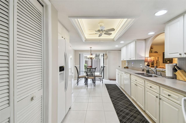 3476 Tarpon Woods Blvd, Palm Harbor, FL 34685 - kitchen with white appliances, a tray ceiling, a sink, arched walkways, and light tile patterned floors