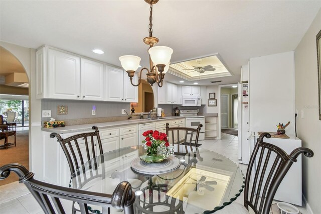 3476 Tarpon Woods Blvd, Palm Harbor, FL 34685 - dining room featuring arched walkways, a raised ceiling, light tile patterned flooring, recessed lighting, and a ceiling fan