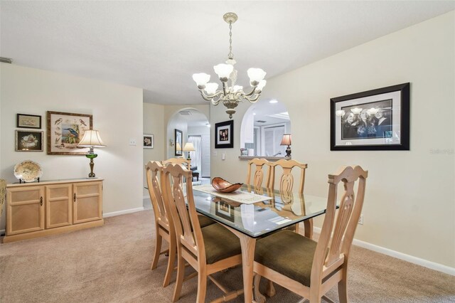 3476 Tarpon Woods Blvd, Palm Harbor, FL 34685 - dining space featuring arched walkways, light colored carpet, a chandelier, and baseboards