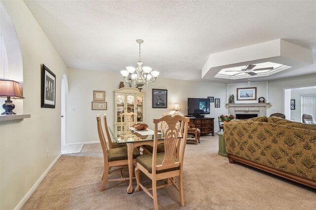 3476 Tarpon Woods Blvd, Palm Harbor, FL 34685 - dining area featuring light colored carpet, a fireplace, ceiling fan, a chandelier, and baseboards