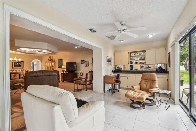 3476 Tarpon Woods Blvd, Palm Harbor, FL 34685 - living room with a textured ceiling, light tile patterned floors, a ceiling fan, arched walkways, and a chandelier