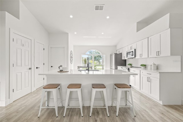 10538 Juliano Dr, Riverview, FL 33569 - kitchen with appliances with stainless steel finishes, a center island with sink, a breakfast bar area, white cabinets, and recessed lighting
