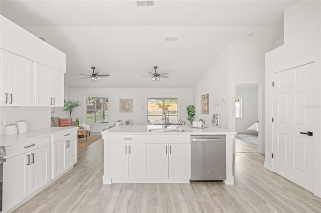 10538 Juliano Dr, Riverview, FL 33569 - kitchen with stainless steel dishwasher, open floor plan, vaulted ceiling, light countertops, and white cabinets