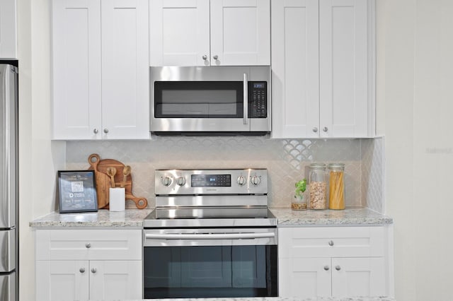 4121 W San Nicholas St, Tampa, FL 33629 - kitchen with stainless steel appliances, white cabinets, and decorative backsplash