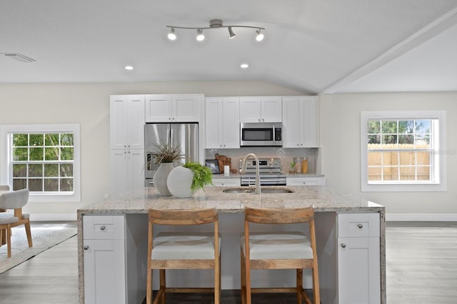 4121 W San Nicholas St, Tampa, FL 33629 - kitchen with appliances with stainless steel finishes, a sink, baseboards, white cabinetry, and tasteful backsplash
