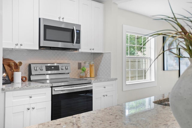 4121 W San Nicholas St, Tampa, FL 33629 - kitchen with stainless steel appliances, decorative backsplash, white cabinetry, and light stone counters