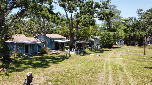 5680 77th Ave N, Pinellas Park, FL 33781 - view of green lawn featuring an outdoor structure and view of wooded area