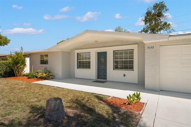 5122 Chet Dr, New Port Richey, FL 34652 - single story home with brick siding, a front yard, covered porch, and an attached garage