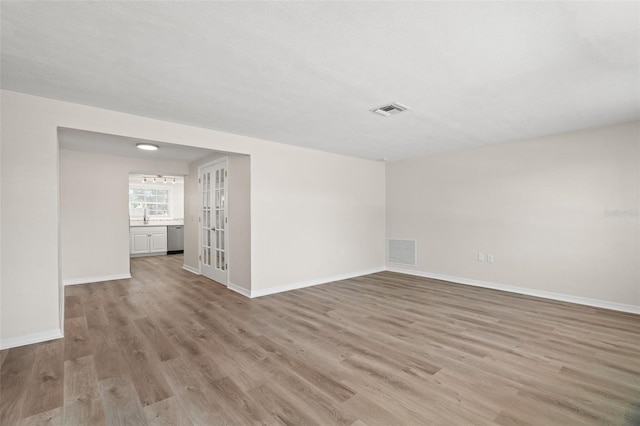5122 Chet Dr, New Port Richey, FL 34652 - unfurnished room with light wood-type flooring, baseboards, a sink, and french doors