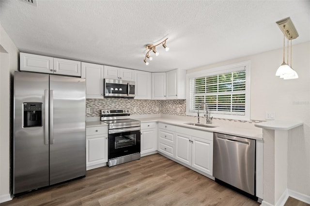 5122 Chet Dr, New Port Richey, FL 34652 - kitchen featuring stainless steel appliances, a sink, white cabinets, tasteful backsplash, and light countertops