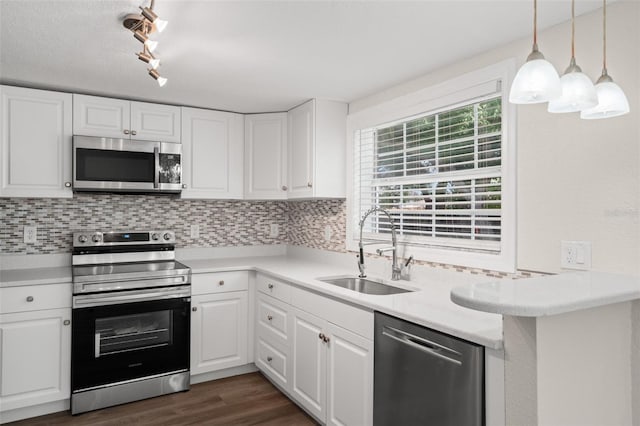 5122 Chet Dr, New Port Richey, FL 34652 - kitchen featuring appliances with stainless steel finishes, a sink, tasteful backsplash, and white cabinetry