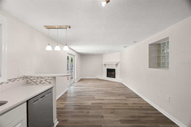 5122 Chet Dr, New Port Richey, FL 34652 - unfurnished living room featuring dark wood-type flooring, a large fireplace, a textured ceiling, and baseboards