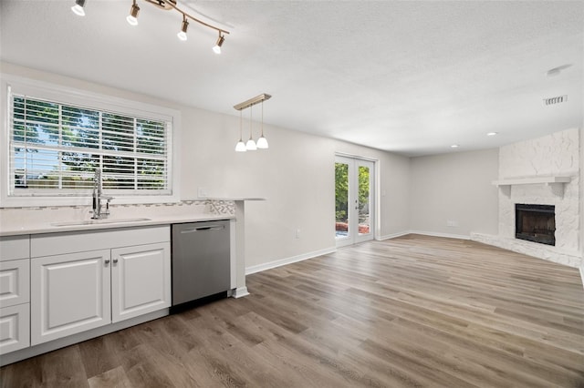 5122 Chet Dr, New Port Richey, FL 34652 - kitchen featuring stainless steel dishwasher, a sink, light wood-style flooring, a stone fireplace, and open floor plan