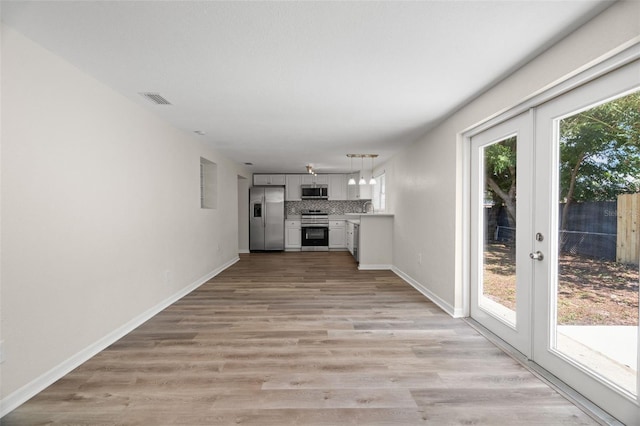 5122 Chet Dr, New Port Richey, FL 34652 - unfurnished living room with plenty of natural light, light wood finished floors, a sink, and baseboards