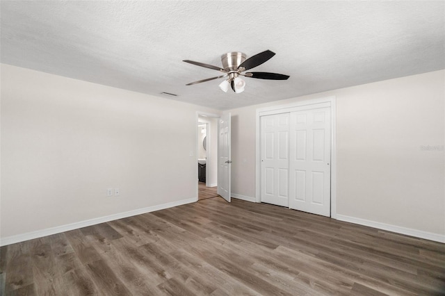 5122 Chet Dr, New Port Richey, FL 34652 - unfurnished bedroom featuring wood finished floors, baseboards, a closet, a textured ceiling, and a ceiling fan