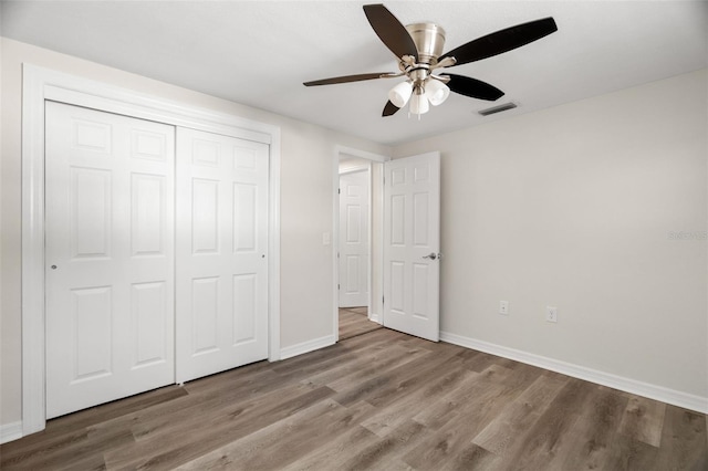 5122 Chet Dr, New Port Richey, FL 34652 - unfurnished bedroom with wood finished floors, baseboards, a closet, and a ceiling fan