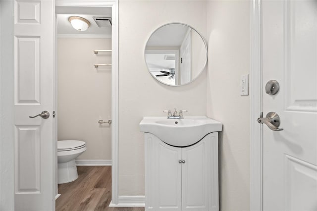 5122 Chet Dr, New Port Richey, FL 34652 - bathroom with ceiling fan, toilet, vanity, wood finished floors, and baseboards