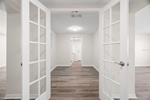 5122 Chet Dr, New Port Richey, FL 34652 - hallway with wood finished floors, baseboards, and french doors