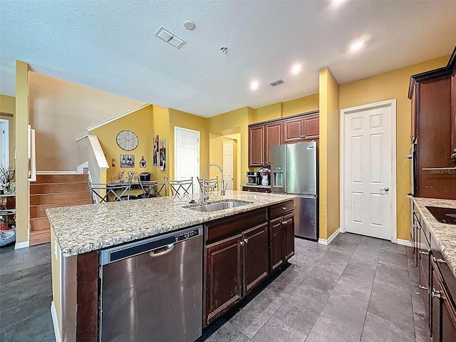 4916 Rolling Green Dr, Wesley Chapel, FL 33543 - kitchen with appliances with stainless steel finishes, a sink, an island with sink, and light stone counters