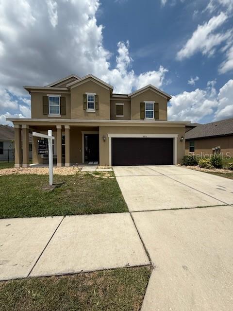 4916 Rolling Green Dr, Wesley Chapel, FL 33543 - traditional-style house with stucco siding, driveway, and an attached garage