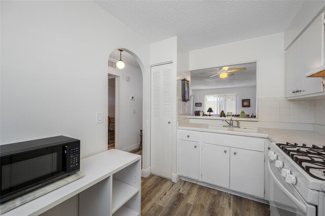 2928 Feather Dr, Clearwater, FL 33759 - kitchen featuring black microwave, white gas range, light countertops, and a textured ceiling