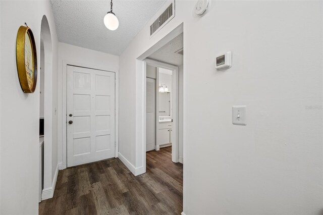 2928 Feather Dr, Clearwater, FL 33759 - corridor with dark wood-style floors, baseboards, and a textured ceiling