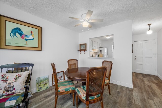 2928 Feather Dr, Clearwater, FL 33759 - dining area featuring wood finished floors, ceiling fan, baseboards, and a textured ceiling