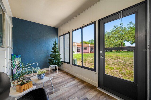 2928 Feather Dr, Clearwater, FL 33759 - sunroom featuring wood finished floors, a textured wall, and baseboards