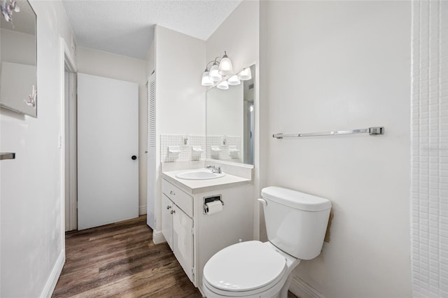 2928 Feather Dr, Clearwater, FL 33759 - bathroom with vanity, toilet, wood finished floors, baseboards, and a textured ceiling