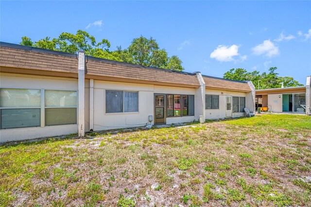 2928 Feather Dr, Clearwater, FL 33759 - rear view of property featuring mansard roof and a yard