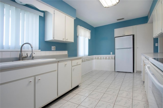 1009 Andover Cir, Sun City Center, FL 33573 - kitchen with freestanding refrigerator, a sink, light countertops, white cabinets, and stove