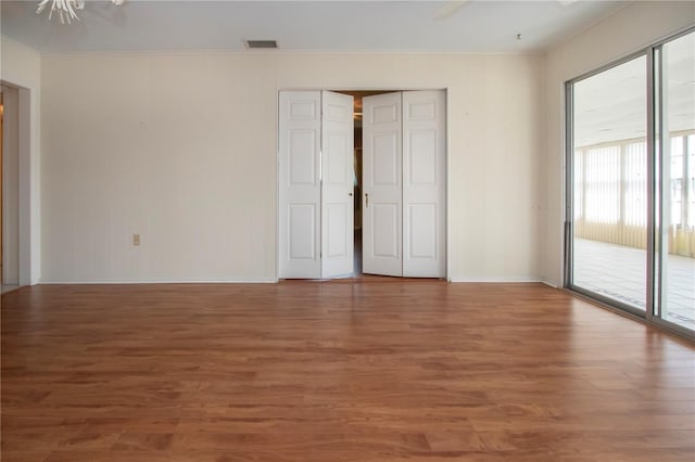 1009 Andover Cir, Sun City Center, FL 33573 - unfurnished bedroom featuring ornamental molding, access to exterior, wood finished floors, baseboards, and ceiling fan