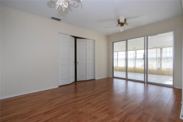 1009 Andover Cir, Sun City Center, FL 33573 - unfurnished bedroom featuring access to outside, wood finished floors, crown molding, baseboards, and a ceiling fan