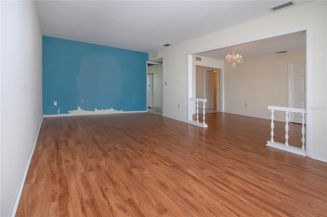 1009 Andover Cir, Sun City Center, FL 33573 - unfurnished room featuring a chandelier, light wood-style flooring, and baseboards