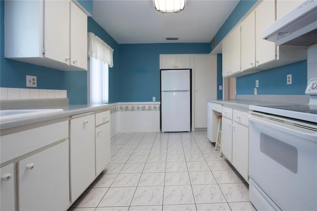 1009 Andover Cir, Sun City Center, FL 33573 - kitchen with white appliances, under cabinet range hood, light countertops, and white cabinets