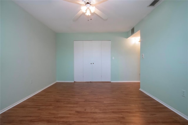 1009 Andover Cir, Sun City Center, FL 33573 - unfurnished bedroom featuring wood finished floors, a closet, baseboards, and ceiling fan