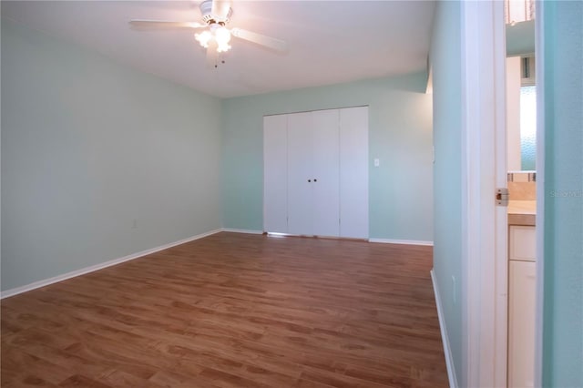 1009 Andover Cir, Sun City Center, FL 33573 - unfurnished bedroom featuring wood finished floors, a closet, baseboards, and a ceiling fan