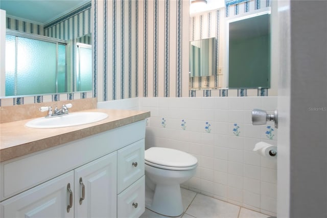 1009 Andover Cir, Sun City Center, FL 33573 - bathroom featuring wallpapered walls, toilet, a stall shower, tile patterned flooring, and tile walls