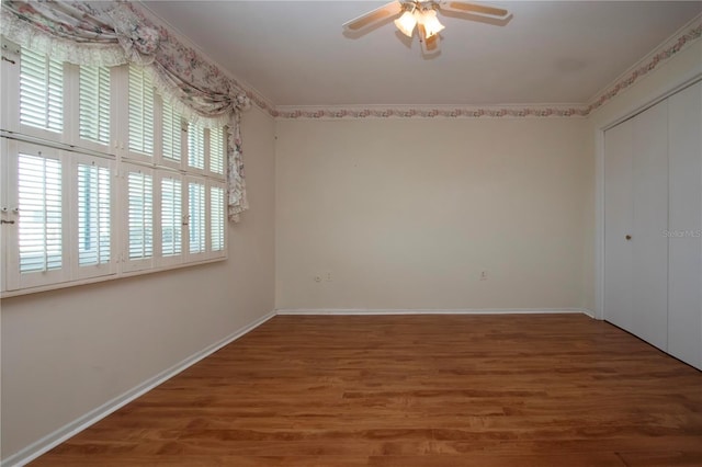 1009 Andover Cir, Sun City Center, FL 33573 - unfurnished bedroom with wood finished floors, baseboards, a closet, and ceiling fan