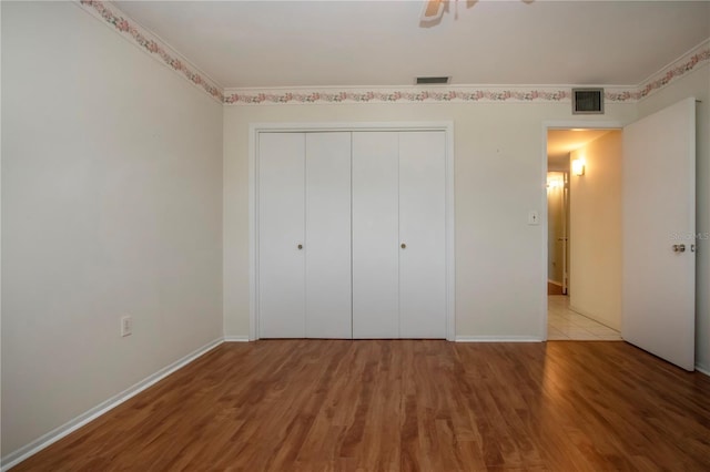 1009 Andover Cir, Sun City Center, FL 33573 - unfurnished bedroom with wood finished floors, a closet, and baseboards