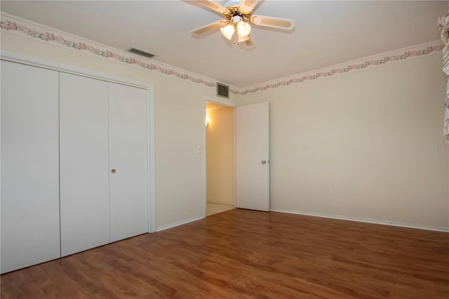 1009 Andover Cir, Sun City Center, FL 33573 - unfurnished bedroom with wood finished floors, a closet, baseboards, and a ceiling fan
