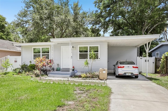 1015 13th Ave NW, Largo, FL 33770 - view of front of property with concrete driveway, an attached carport, and a gate