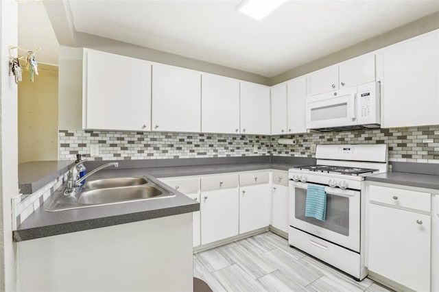 1015 13th Ave NW, Largo, FL 33770 - kitchen featuring white appliances, dark countertops, and white cabinetry