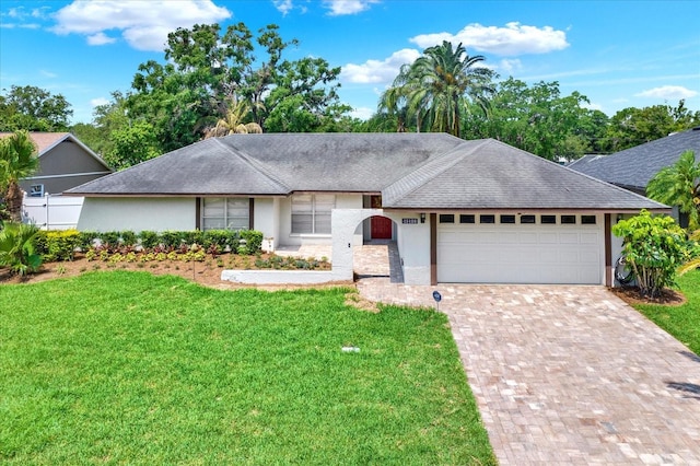 15108 Springview St, Tampa, FL 33624 - ranch-style house featuring stucco siding, a front lawn, an attached garage, and decorative driveway