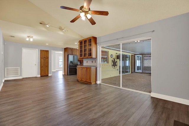15108 Springview St, Tampa, FL 33624 - unfurnished living room featuring dark wood-style flooring, vaulted ceiling, ceiling fan, and baseboards