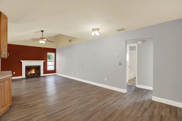 15108 Springview St, Tampa, FL 33624 - unfurnished living room featuring ceiling fan, dark wood-style floors, a fireplace with flush hearth, lofted ceiling, and baseboards