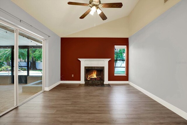 15108 Springview St, Tampa, FL 33624 - unfurnished living room featuring wood finished floors, vaulted ceiling, a fireplace with flush hearth, ceiling fan, and baseboards